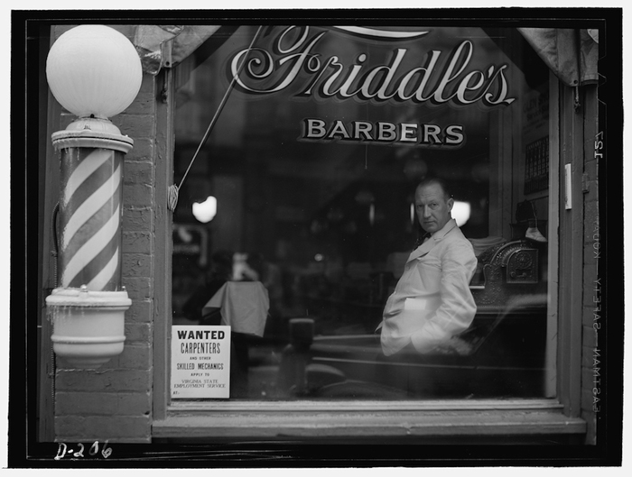 Photograph of Friddle’s Barbers at 80 South Main Street (1941) by John Vachon. This image, taken by a Farm Securities Administration photographer, not only depicts small-town America, but also promotes a New Deal federal employment program.