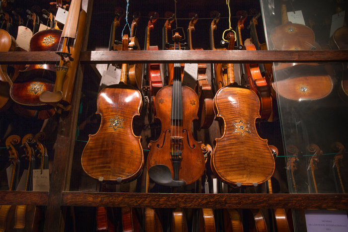 Five Klezmer Star of David violins hang in one of Amnon Weinstein’s instrument cabinets. 
