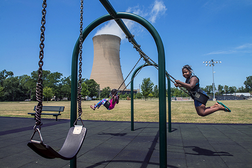 Playground near the shore of Lake Michigan, with the cooling tower of a coal and natural gas-fired power plant looming in the background, Michigan City, IN (2016).