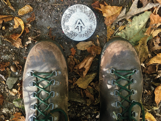 U.S. Geological Survey benchmarks, like the one flanked by the author’s battered boots, officially pinpoint the path of the Appalachian Trail (AT). 