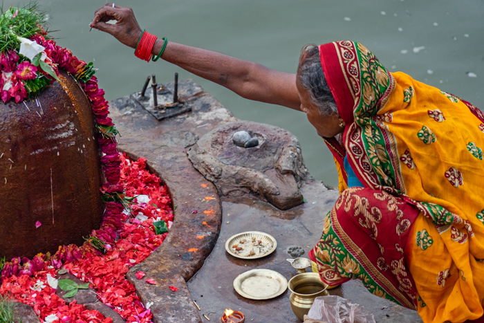 A woman makes an offering to Shiva. All devoted beings are permitted to make offerings to Shiva directly, without necessity of a priestly intermediary.