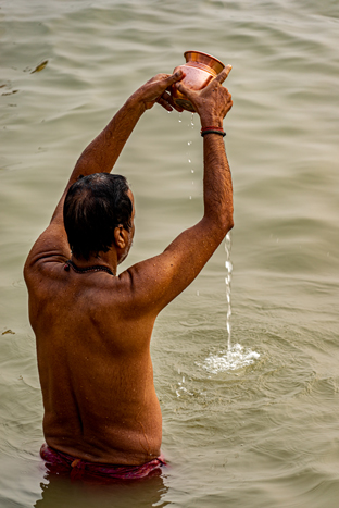 Morning prayers to the Sun. Ganga water is a fit offering; it is gathered in a copper pot and given to the Sun every morning.  